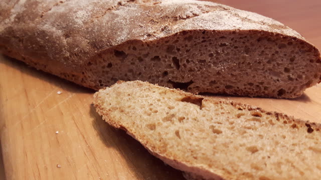 Angeschnittenes Dinkelbaguette auf einem Holzbrett
